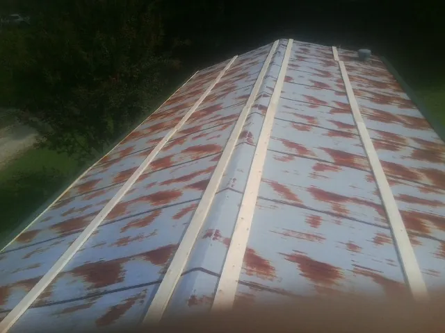 Rusted metal roof panels with new wood purlins before replacement — Storm Damage Roof Repair in Nedrow by Roofing Brothers